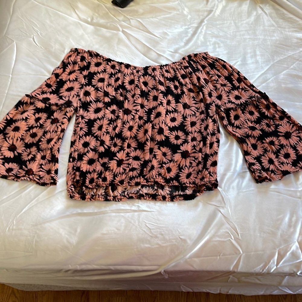 Flower off the shoulders crop top. Elastic top and bottom with 3/4 bell sleeves